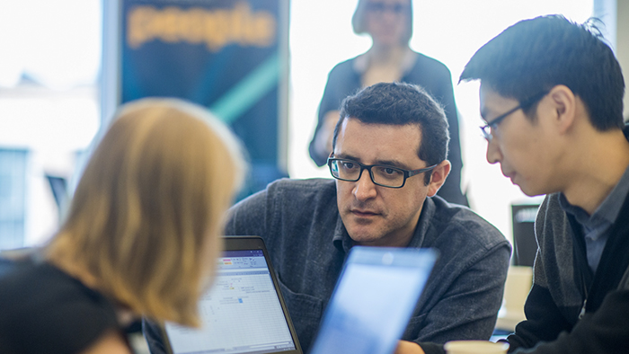 Three innovators with laptops have an intense discussion