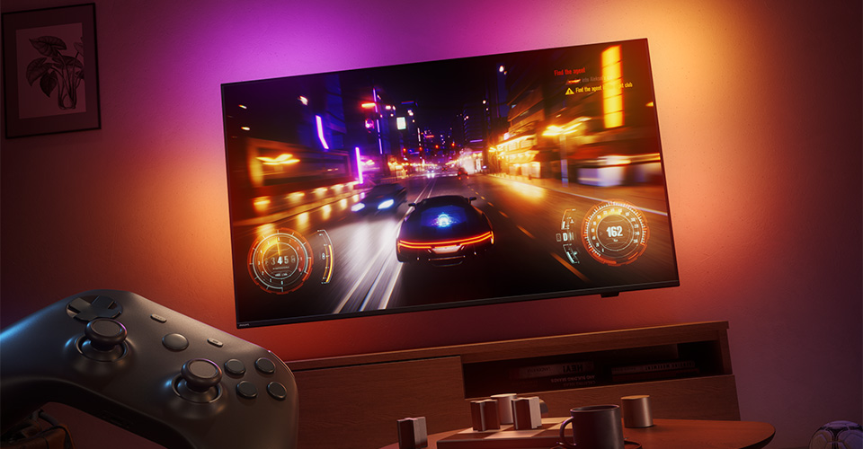 Гоночна відеогра відображається на телевізорі Philips Ambilight у слабо освітленій кімнаті.