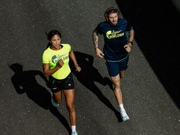 Два бігуни біжать, щоб залишитися попереду автомобіля.