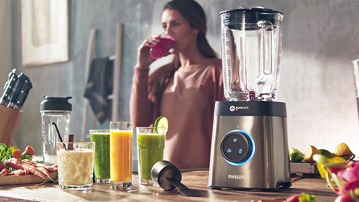 жінка користується блендером Philips